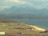 View towards sandy beach with sea and mountains behind